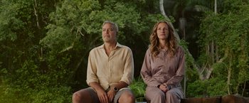 Movie still from “Ticket to Paradise” (2022), directed by Ol Parker – A man and a woman sitting next to each other on a bench; Medium shot, Low angle