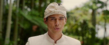 Movie still from “Ticket to Paradise” (2022), directed by Ol Parker – A man wearing a white head band and a white shirt; Close Up shot, Low angle