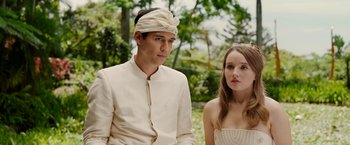 Movie still from “Ticket to Paradise” (2022), directed by Ol Parker – A man and a woman standing next to each other in front of trees; Medium shot, Over the shoulder angle
