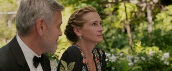 Movie still from “Ticket to Paradise” (2022), directed by Ol Parker – A man and a woman are standing in a garden; Close Up shot, Over the shoulder angle