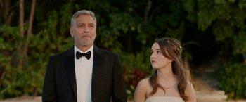 Movie still from “Ticket to Paradise” (2022), directed by Ol Parker – A man and a woman standing next to each other in front of trees; Close Up shot, Over the shoulder angle