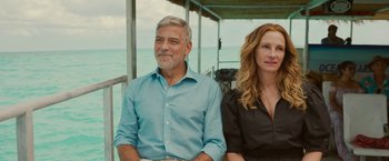 Movie still from “Ticket to Paradise” (2022), directed by Ol Parker – A man and a woman sitting next to each other on a boat; Medium shot, Over the shoulder angle