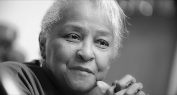 An older woman is smiling for the camera