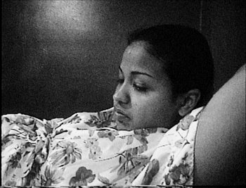 Movie still from “Time” (2020), directed by Garrett Bradley – Black and white photograph of a woman laying in bed; Close Up shot, High angle