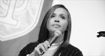 Movie still from “Time” (2020), directed by Garrett Bradley – A black and white photo of a woman holding a microphone; Close Up shot, Low angle