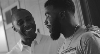 Two men smiling and talking to each other