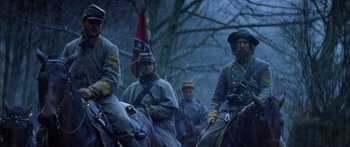 Movie still from “Timecop” (1994), directed by Peter Hyams – Several civil war re - enactments are being held in a wooded area; Medium shot, Low angle