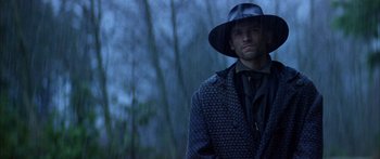 Movie still from “Timecop” (1994), directed by Peter Hyams – A man wearing a black hat and a coat; Close Up shot, Low angle