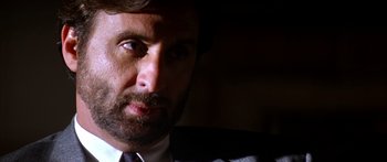 Movie still from “Timecop” (1994), directed by Peter Hyams – A person wearing a suit and tie; Close Up shot, Low angle