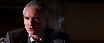 Movie still from “Timecop” (1994), directed by Peter Hyams – A person wearing a suit and tie; Close Up shot, Low angle