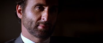 Movie still from “Timecop” (1994), directed by Peter Hyams – A man with a beard looking at the camera; Close Up shot, Low angle