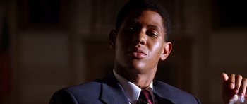 Movie still from “Timecop” (1994), directed by Peter Hyams – A man wearing a suit and tie looking up; Close Up shot, Low angle