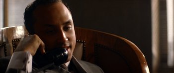 Movie still from “Timecop” (1994), directed by Peter Hyams – A person sitting in a chair holding a phone; Close Up shot, High angle