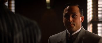 Movie still from “Timecop” (1994), directed by Peter Hyams – A person wearing a suit and tie; Close Up shot, Over the shoulder angle