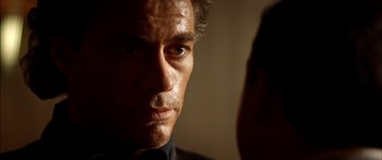 Movie still from “Timecop” (1994), directed by Peter Hyams – A man's face in the dark; Close Up shot, Over the shoulder angle