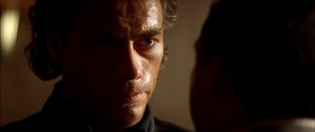 Movie still from “Timecop” (1994), directed by Peter Hyams – A man's face in the dark; Close Up shot, Over the shoulder angle