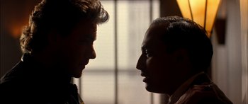 Movie still from “Timecop” (1994), directed by Peter Hyams – Two men face each other in a room; Close Up shot, Low angle