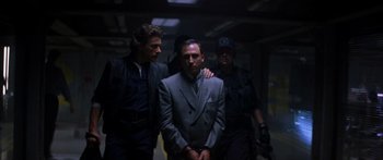Movie still from “Timecop” (1994), directed by Peter Hyams – A group of men standing next to each other in a dark room; Medium shot, Low angle