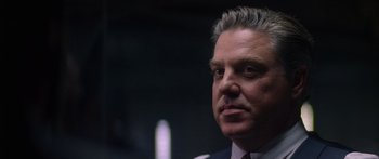 Movie still from “Timecop” (1994), directed by Peter Hyams – A person wearing a suit and tie; Close Up shot, Low angle