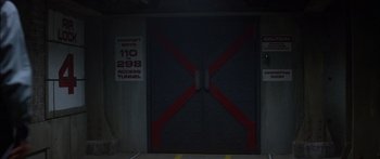 Movie still from “Timecop” (1994), directed by Peter Hyams – A black door with red stripes on it's side; Wide shot, High angle