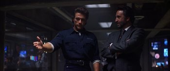 Movie still from “Timecop” (1994), directed by Peter Hyams – Two men standing next to each other in a dark room; Medium shot, Low angle