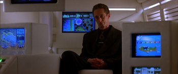 Movie still from “Timecop” (1994), directed by Peter Hyams – A man sitting in front of a television screen; Close Up shot, Low angle