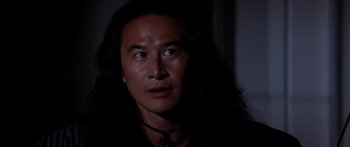 Movie still from “Timecop” (1994), directed by Peter Hyams – A person with long black hair; Close Up shot, Over the shoulder angle