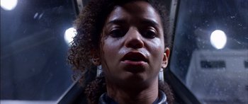 Movie still from “Timecop” (1994), directed by Peter Hyams – A person with curly black hair; Close Up shot, Low angle