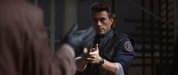 Movie still from “Timecop” (1994), directed by Peter Hyams – A person holding something in his hand; Close Up shot, Over the shoulder angle