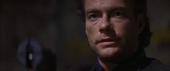 Movie still from “Timecop” (1994), directed by Peter Hyams – A man's face in the dark; Close Up shot, Over the shoulder angle