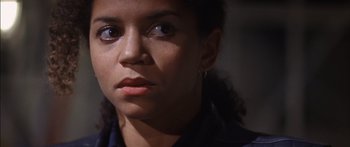 Movie still from “Timecop” (1994), directed by Peter Hyams – A person looking at the camera; Close Up shot, Over the shoulder angle
