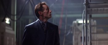 Movie still from “Timecop” (1994), directed by Peter Hyams – A man in a suit and tie looking up; Close Up shot, Low angle