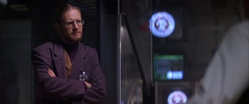 Movie still from “Timecop” (1994), directed by Peter Hyams – A man standing in front of a mirror with a camera; Medium shot, Over the shoulder angle