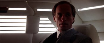 Movie still from “Timecop” (1994), directed by Peter Hyams – A person wearing a suit and tie; Close Up shot, Low angle