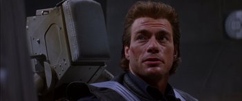 Movie still from “Timecop” (1994), directed by Peter Hyams – A person sitting in a chair; Close Up shot, Low angle