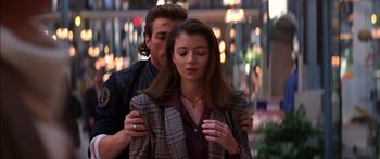 Movie still from “Timecop” (1994), directed by Peter Hyams – A man and a woman standing next to each other; Medium shot, Over the shoulder angle