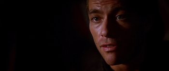 Movie still from “Timecop” (1994), directed by Peter Hyams – A man's face in the dark; Close Up shot, Over the shoulder angle