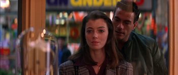 Movie still from “Timecop” (1994), directed by Peter Hyams – A young woman standing next to a man in front of a building; Close Up shot, Over the shoulder angle