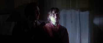 Movie still from “Timecop” (1994), directed by Peter Hyams – A man and a woman standing next to each other in front of a window; Close Up shot, Low angle