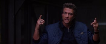 Movie still from “Timecop” (1994), directed by Peter Hyams – A man in a blue jacket is pointing to the side; Close Up shot, Over the shoulder angle