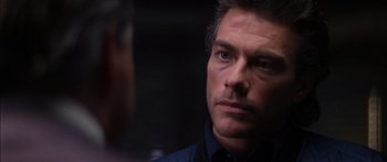 Movie still from “Timecop” (1994), directed by Peter Hyams – A person wearing a suit and tie; Close Up shot, Over the shoulder angle