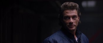 Movie still from “Timecop” (1994), directed by Peter Hyams – A person wearing a blue jacket; Close Up shot, Over the shoulder angle