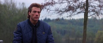 Movie still from “Timecop” (1994), directed by Peter Hyams – A person wearing a jacket near a tree; Close Up shot, Over the shoulder angle
