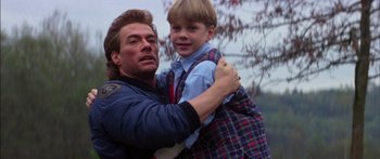 Movie still from “Timecop” (1994), directed by Peter Hyams – A man and a boy are hugging each other; Close Up shot, Low angle
