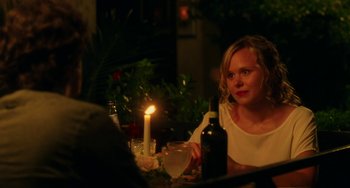 Movie still from “To Rome with Love” (2012), directed by Woody Allen – A woman sitting at a dinner table with a candle; Close Up shot, Over the shoulder angle