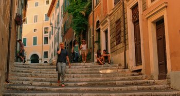 Movie still from “To Rome with Love” (2012), directed by Woody Allen – A group of people sitting and standing on some steps; Wide shot, Low angle