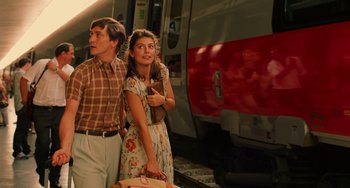 Movie still from “To Rome with Love” (2012), directed by Woody Allen – A man and a woman standing in front of a train; Medium shot, Low angle