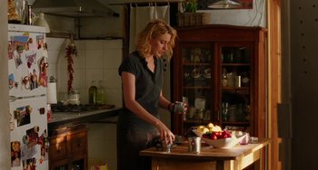 Movie still from “To Rome with Love” (2012), directed by Woody Allen – A woman standing in a kitchen preparing a meal; Medium shot, Over the shoulder angle