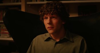 Movie still from “To Rome with Love” (2012), directed by Woody Allen – A man with curly brown hair sitting in a chair; Close Up shot, Over the shoulder angle