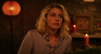 Movie still from “To Rome with Love” (2012), directed by Woody Allen – A woman sitting in front of a candle in a room; Close Up shot, Over the shoulder angle